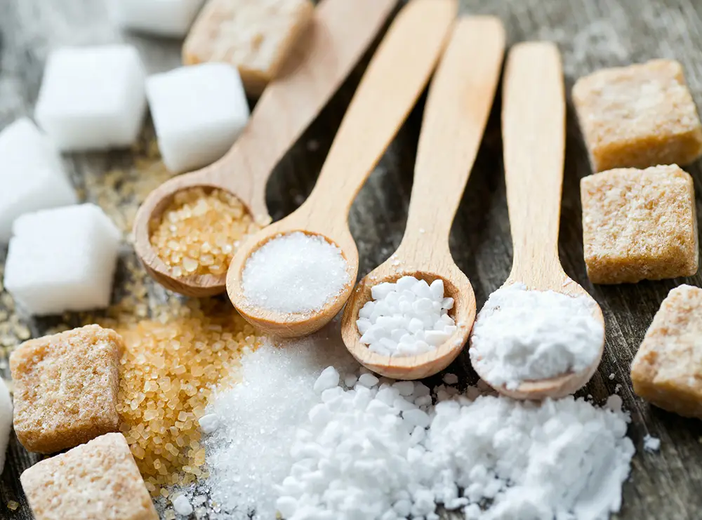 different-types-of-sugar-on-spoons-background